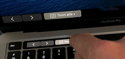Een stilgehouden vinger op de Touch Bar levert een vergrote Touch Bar op het
beeldscherm op