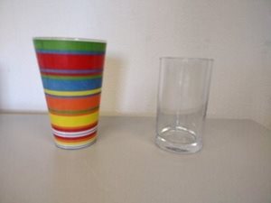 Een doorzichtig glas naast een gekleurde
beker.