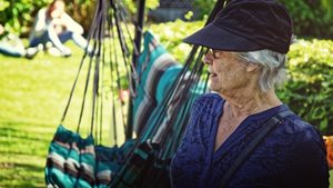 oudere vrouw draagt pet met grote kleprand tegen de
zon