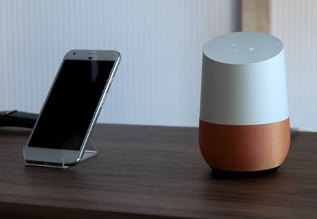 Smartphone en Google Home aast elkaar op
tafel