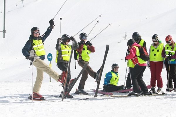 Groep alpineskiers die een startgroet
maken