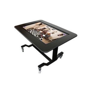 De BeleefTV. Een tafel zo groot als een bureau. het midden is een groot
touchscreen zo groot als een flink televisiescherm. Om het scherm heen zit een
15 cm brede rand van hout waar je op kunt
leunen.