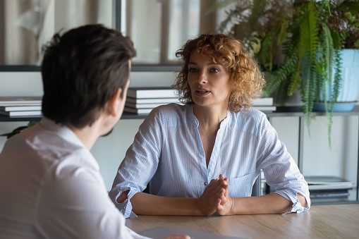 Professional en client voeren aan tafel een
gesprek