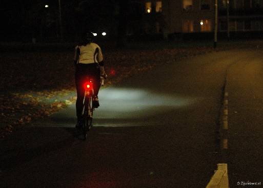 Fietser in het donker mer brandend voor en
achterlicht