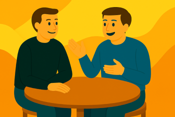 Twee mannen met elkaar in gesprek aan een ronde
tafel.