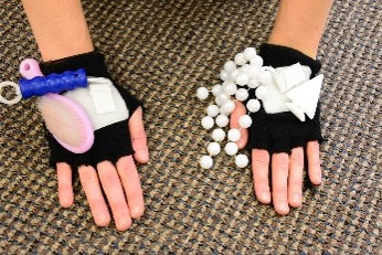 klittenbandhandschoenen waarop ketting en borsteltje vast
zitten