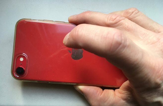 Vinger die op de achterkant van de iPhone
tikt