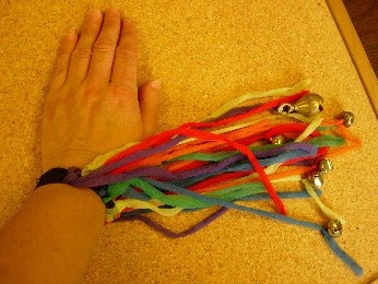 polsband met veters waar belletjes aan
vastzitten