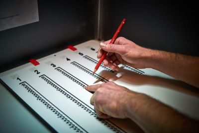 Stemmal, dichtgeklapt. De stemmer telt de rondjes om het rondje te vinden dat
hij voor de kandidaat van zijn keuze met het potlood gaat
inkleuren.