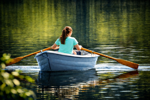 Jonge vrouw in roeiboot. De roeiboot van verlies wordt verderop
uitgelegd.