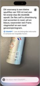 Foto van een metalen flesje, met daarbij de gedetailleerde beschrijving die Visuele Intelligentie genereert: “Dit voorwerp is een kleine spuitfles van 100 ml met een fel oranje dop die duidelijk opvalt. De fles zelf is zilverkleurig met accenten in rood, wit en blauw, waaronder een Frans vlagmotief en een rood gevarenpictogram.” 