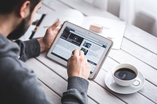 Man die op zijn tablet een tekst
leest