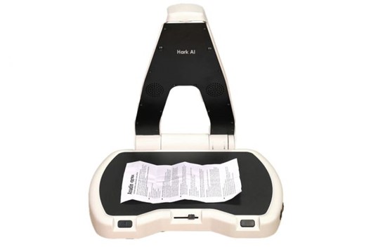 De Hark AI. De camera arm is open geklapt. Op het plateau ligt een document.