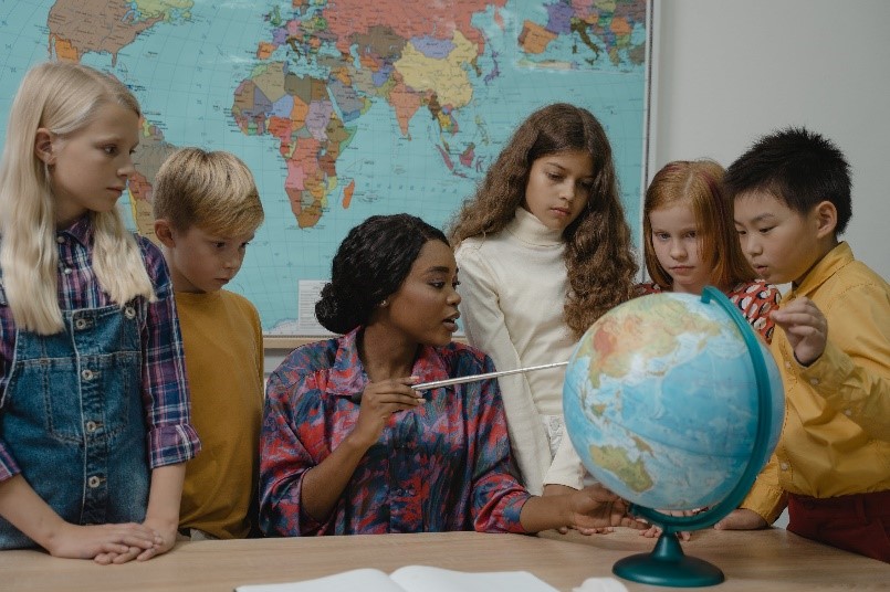 Kinderen in de klas die een wereldbol bestuderen (foto:
freepics)