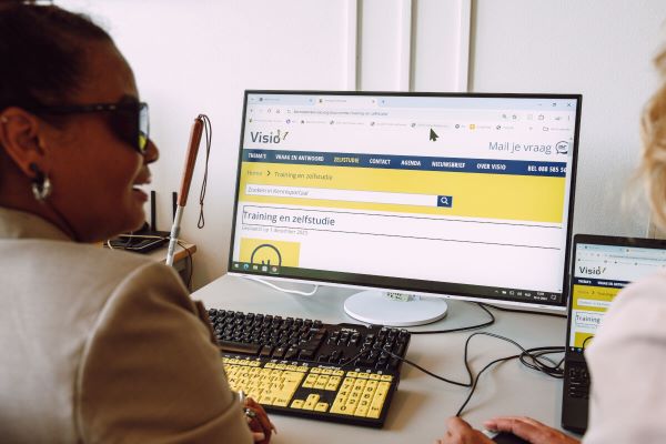 Slechtziende vrouw die op een beeldscherm met vergrote weergave
werkt