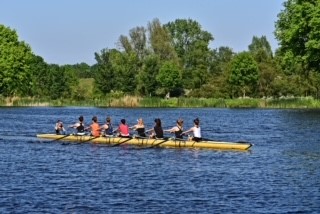 Acht roeiers met een stuurman roeien in de
natuur